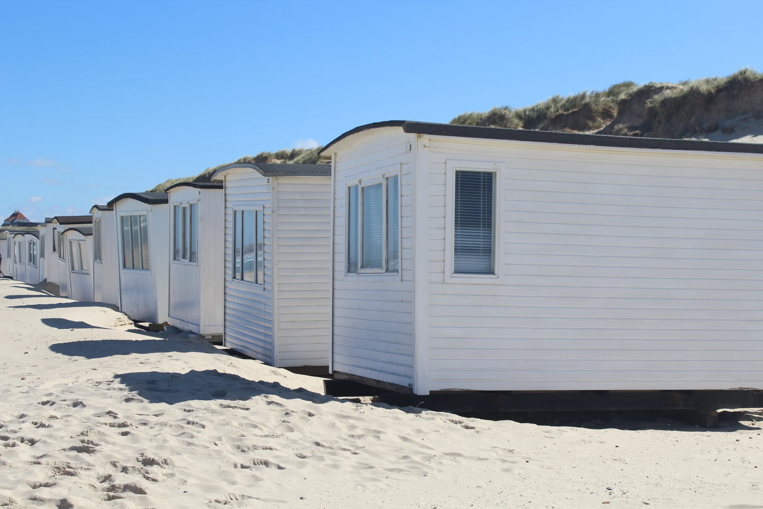 1-row-white-cabins-lokken-beach-denmark